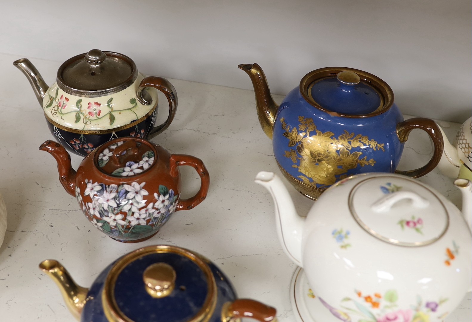 A quantity of various teapots including Belleek, Japanese Satsuma etc.